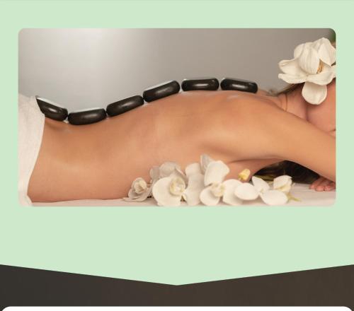 a woman wearing a black bikini with flowers on a shelf at Hotel Tierra de Volcanes in San Ramón