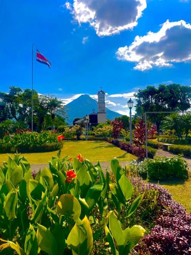 a park with a flag and a lighthouse in the background at Hotel Tierra de Volcanes in San Ramón