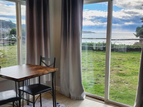 a table and chairs in a room with a large window at Inn at Arch Rock in Depoe Bay