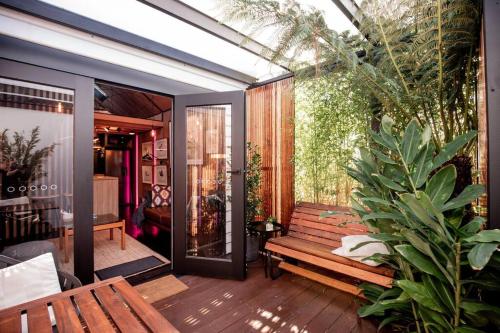 a patio with a wooden bench and a plant at The Shed in Hobart
