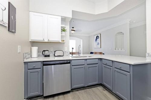uma cozinha com armários cinzentos e um balcão branco em Orlando Retreat 2B2B / Disney-Universal-SeaWorld em Orlando