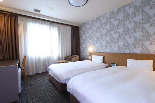 Postel nebo postele na pokoji v ubytování Dormy Inn Chiba City Soga