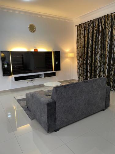 a living room with a couch and a flat screen tv at SW Homestay Kota Warisan, Sepang in Sepang