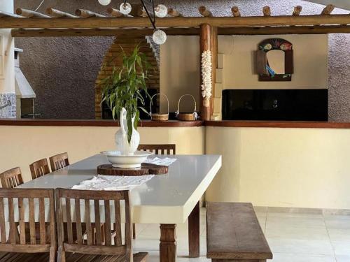 a dining room table with chairs and a vase on it at Casa San Francisco in Porto Seguro