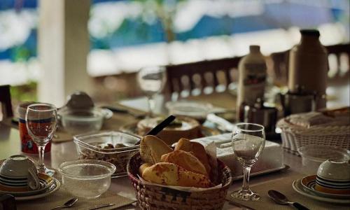 a table topped with baskets of bread and glasses of wine at Casa San Francisco in Porto Seguro