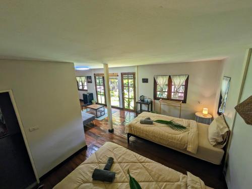 a bedroom with two beds and a living room at Vanara Bungalows in Ko Chang