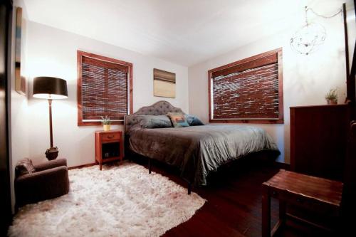 a bedroom with a bed and a table and window at Glimmer Chalet Treetop A-frame cabin lake view in Lake Arrowhead