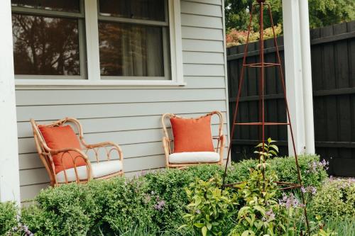 two chairs sitting on the front porch of a house at Dorothea- stylishly designed home in Trentham in Trentham