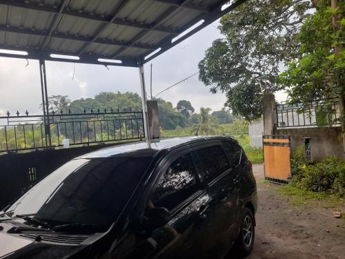 un coche aparcado bajo un edificio con techo en Lombok cahaya, en Mantang