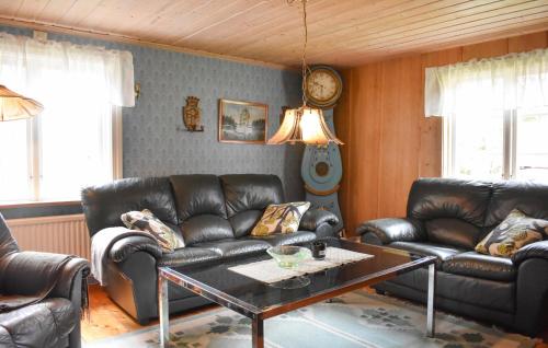 a living room with leather couches and a coffee table at Holiday Home Bjurabysset C-O Pettersso Holmsjö in Holmsjö