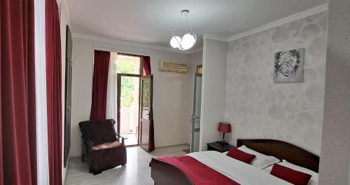 a bedroom with a bed and a chair and a window at Sighnaghi Central in Sighnaghi