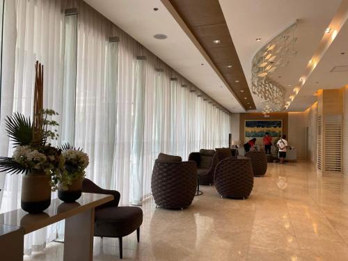 eine Lobby mit einem Wartezimmer mit Stühlen und Fenstern in der Unterkunft Shore 3 Residences Authentic Japanese-Style Bedroom with Pool View - MOA Complex in Manila