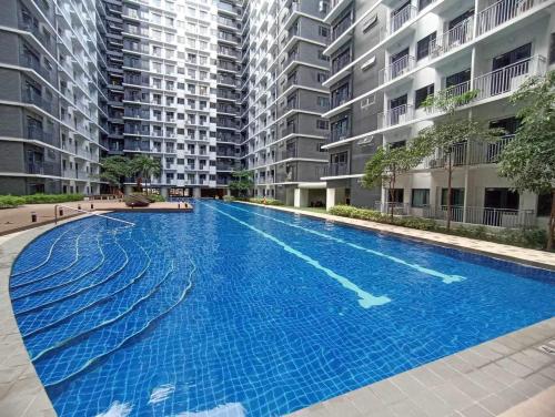 ein leerer Pool vor einigen Apartmentgebäuden in der Unterkunft Shore 3 Residences Authentic Japanese-Style Bedroom with Pool View - MOA Complex in Manila