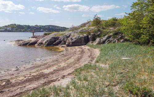 a sandy beach next to a body of water at Stunning Home In Uddevalla With Kitchen in Uddevalla