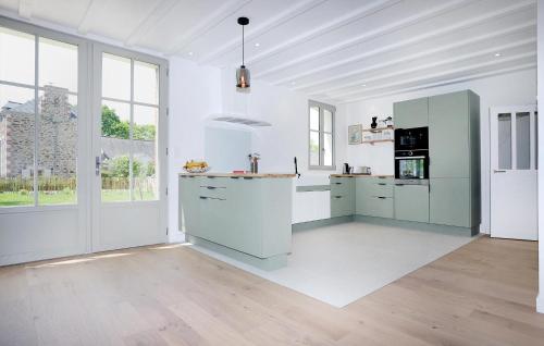 une grande cuisine avec des murs blancs et des armoires vertes dans l'établissement Stunning Home In Le Minihic-Sur-Rance, à Le Minihic-sur-Rance