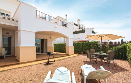 Un patio con una mesa y sillas y una sombrilla. en Stunning Home In Roldán With Kitchen, en Roldán