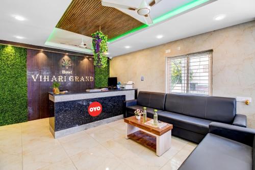 una sala de espera con sofá y barra en Collection O Hotel Vihari Grand, en Vijayawāda