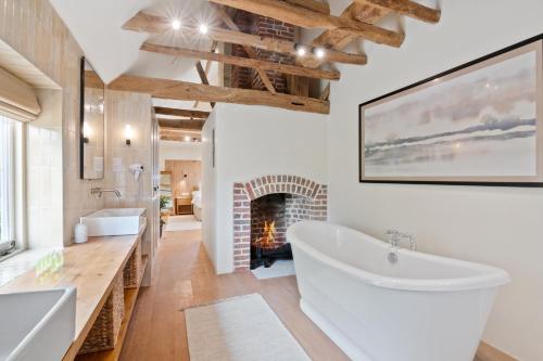 a bathroom with a large tub and a fireplace at Minstrel Court Wedding Venue in Cambridge