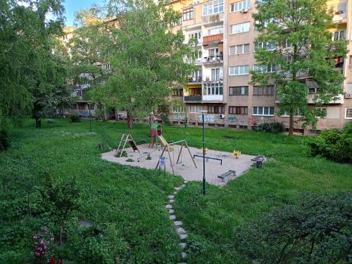 Un parque con zona de juegos infantiles en medio de una ciudad. en Apartment "Relax" - Wilson's Promenade, en Sarajevo
