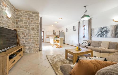 a living room with a tv and a brick wall at Four-Bedroom Holiday Home In Muline in Donje Selo