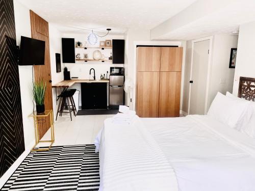 Cet appartement comprend une chambre avec un lit blanc et une cuisine. dans l'établissement A Mid Somerset Dream, à West Kelowna