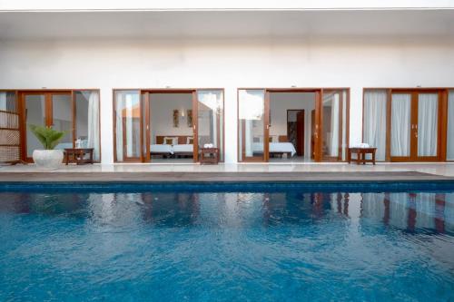 a swimming pool in a villa with glass walls at Blessing Bali in Uluwatu