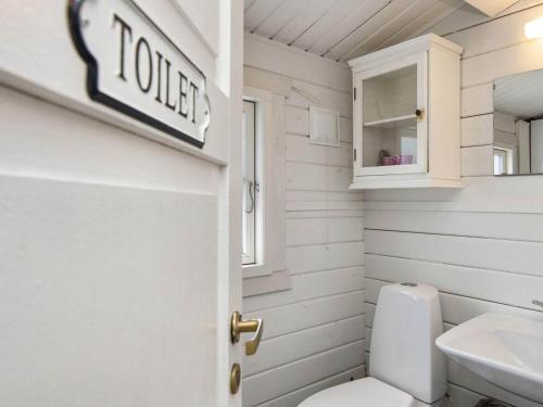 a bathroom with a toilet and a sign on the wall at Holiday home Fanø LII in Fanø