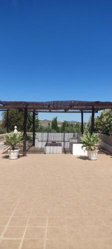 um pavilhão com vasos de plantas num pátio em Las Vistas em Arcos de la Frontera