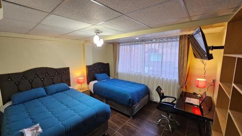 a bedroom with a bed and a desk and a television at Los Profesionales 2-Transporte Aeropuerto Gratis! in Cusco