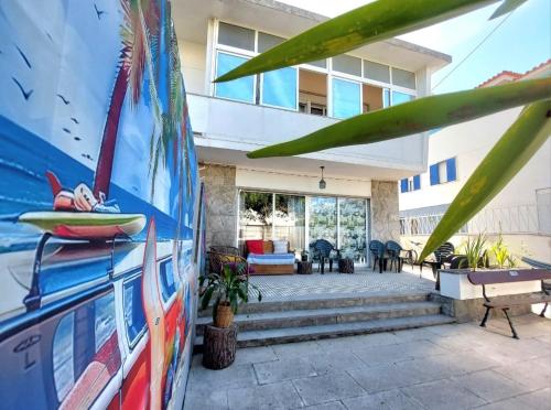 une maison avec une planche de surf peinte sur son côté dans l'établissement Beach life Caparica, à Costa da Caparica