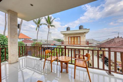 a balcony with chairs and a table and a building at The Kanka Beach House in Nusa Penida