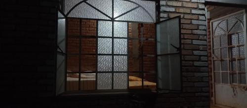 an open window in a room with a brick wall at Villas Carmelita hostal in Paso de las Palmas