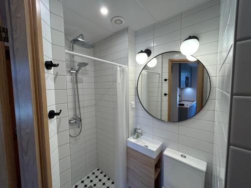 y baño con ducha, lavabo y espejo. en Jon´s 2 Apartments, en Pärnu