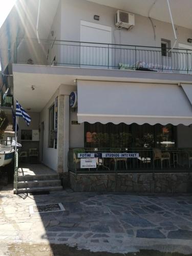 a restaurant with a white awning in front of a building at Hotel Fotini in Kamena Vourla