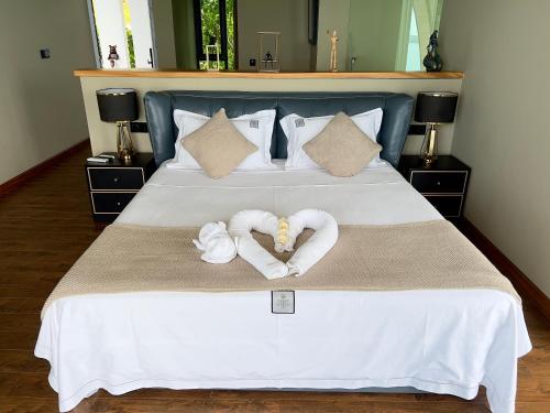 a bed with two towels in the shape of hearts at 苏梅岛观景台海景別墅Golden Coconut Villa 5 超级海景 私密泳池 接送服务 in Koh Samui 