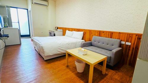 台南市にあるDidi Houseのベッドルーム1室(ベッド1台、ソファ、テーブル付)