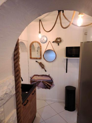 une cuisine avec un évier et un mur avec un miroir dans l'établissement Studio à côté de la Mer, à Argelès-sur-Mer