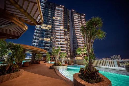 a large apartment building with a swimming pool and palm trees at The Artistry Apartment Cental Saigon Heart Center in Ho Chi Minh City