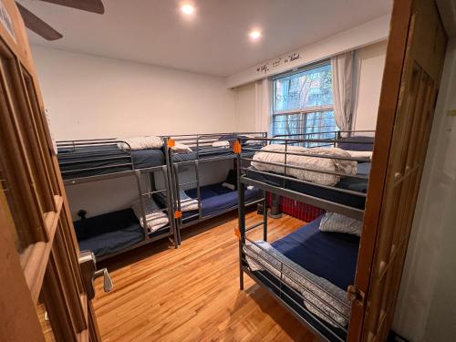 a room with three bunk beds and a window at Auberge PVT Hostel in Montreal