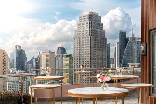 a balcony with tables and a view of a city at Rembrandt Hotel Bangkok in Bangkok
