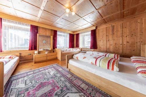 a bedroom with two beds and a rug at Tlisöra Speckstube in Frena