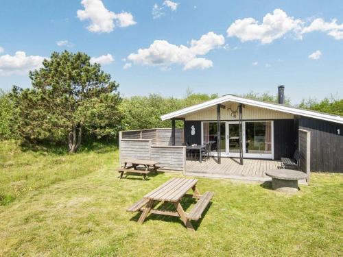 une cabine avec une table de pique-nique et un banc dans l'établissement 6 person holiday home in Fan, à Fanø