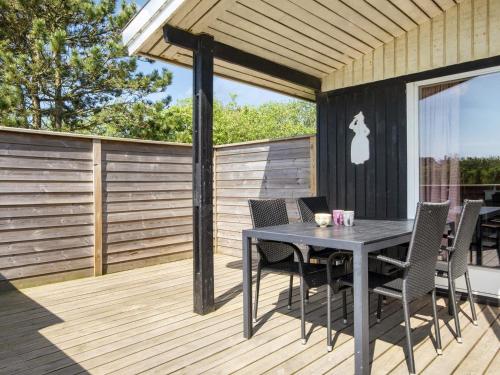 een terras met een tafel en stoelen bij 6 person holiday home in Fan in Fanø