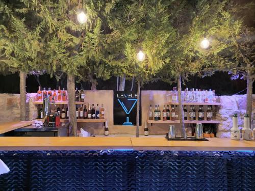 um bar com árvores por cima com garrafas de álcool em Rawa2 Village em Dayr al Qamar