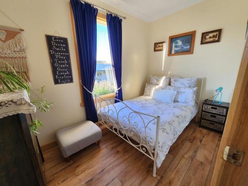 Habitación pequeña con cama y ventana en Ruby's Cottage Farm Stay, en Port Arthur