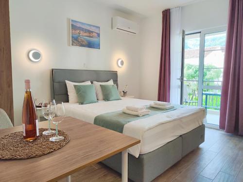 a bedroom with a bed and a table with wine glasses at Bofani Apartments Budva in Budva
