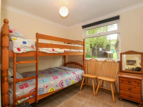 a bedroom with two bunk beds and a window at 245 Riverside Lodge in Caernarfon