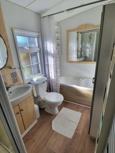 une salle de bain avec toilettes, lavabo et baignoire dans l'établissement MH126 Charmant mobilhome campagne des Yvelines, à Saint-Illiers-la-Ville