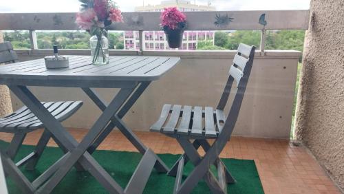 uma mesa e duas cadeiras numa varanda com flores em Azur em Toulouse