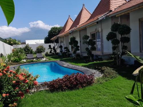 a swimming pool in the yard of a house at Maha Rama Villas Amed in Amed